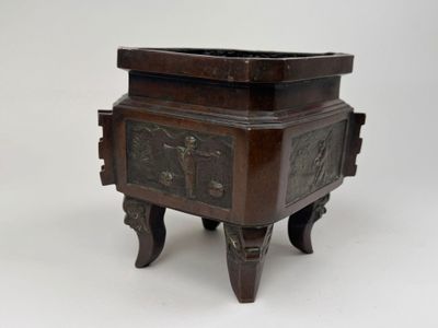 une boîte en bois ornée de sculptures, posée sur un socle
