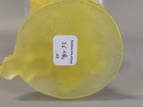 a yellow vase with a label on it sitting on a table