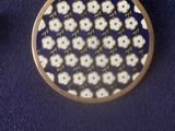 two pieces of metal and a gold plate on a blue surface