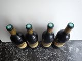four bottles of wine are lined up on a counter