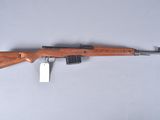 a rifle with a wooden barrel and a tag on it