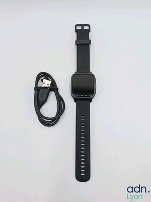 une Apple Watch noire avec un chargeur fixé dessus