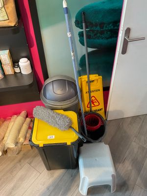a mop, bucket, bucket, and other cleaning supplies on the floor