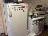 a refrigerator in the kitchen with many magnets on it