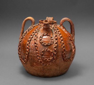 une image représentant un vase marron muni d'une anse, posé sur une surface grise