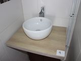 a white sink sitting on a wooden counter in a bathroom