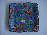 a blue plate with red and green flowers on it