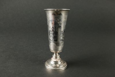 une coupe en argent sur laquelle est représenté un château sur fond noir