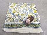a close up of a blanket on a bed with a magazine on it