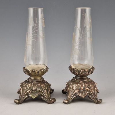 paire de vases en argent et en verre posés sur des socles, sur fond gris