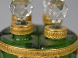 a green glass bottle with two crystal knobs on top