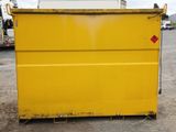 a yellow dumpster sitting in the middle of a parking lot