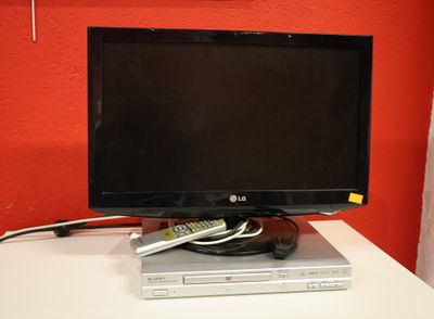 un téléviseur à écran plat posé sur un lecteur DVD