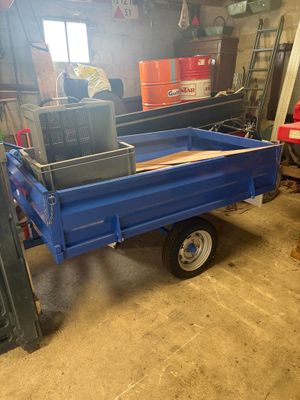 a blue trailer with a box on it in a garage
