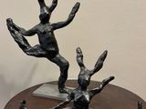 une sculpture en bronze représentant un homme et une femme, posée sur une table