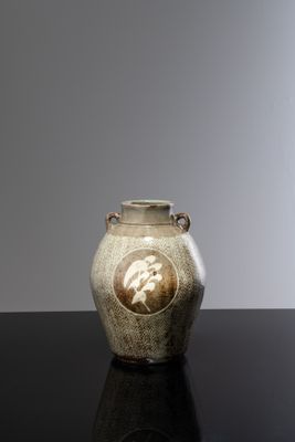 un vase orné d'une image représentant un homme, posé sur une table