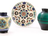 trois vases posés l'un à côté de l'autre sur une surface blanche