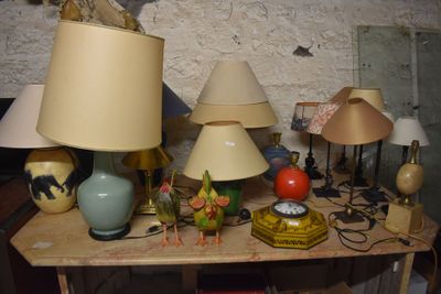 a table with a bunch of lamps and a clock on it