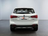 the rear end of a white bmw suv parked in a room
