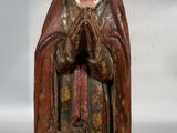 une vieille statue en bois représentant une femme tenant un chien dans ses bras