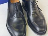 a pair of black leather shoes with laces on them