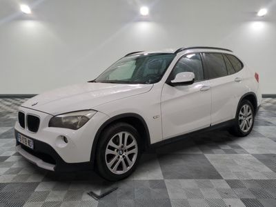 la bmw x1 est garée dans une grande pièce au sol en damier