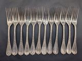 six forks are lined up in a row on a black surface