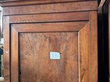 une armoire en bois sur laquelle est posé un chapeau rose