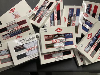 Des cartons de sous-vêtements pour hommes sont empilés sur une table