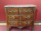 une commode ancienne avec un plateau en marbre, exposée dans un musée