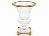 une image représentant un vase en verre à bord doré posé sur un socle