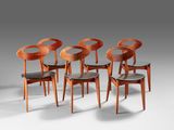 a set of six chairs with black leather seats