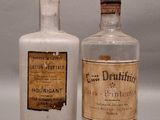two old bottles that are sitting next to each other