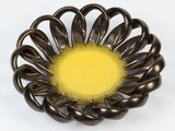 a metal bowl with a yellow center on a white surface