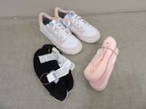 three pairs of shoes and a pink bag on the floor
