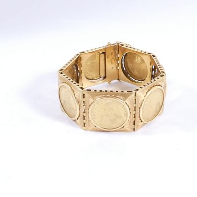 une image d'un gros plan d'un bracelet en or sur une surface blanche