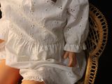 a doll that is sitting on a wicker chair