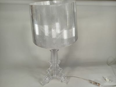 une lampe posée sur une table à côté d'un mur