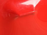 a close up of a red door handle on a red car