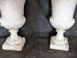 two white vases with flowers in them on a black background