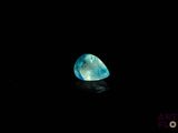 a close up of a blue diamond on a black surface
