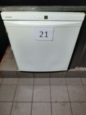 un lave-vaisselle blanc posé au milieu d'un sol carrelé