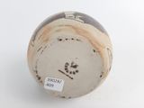 a close up of a vase with a tag on it