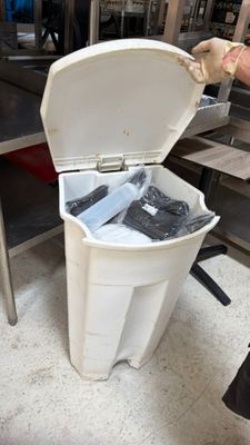 a person that is putting something in a trash can