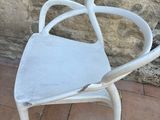 a white chair that is sitting in front of a stone wall