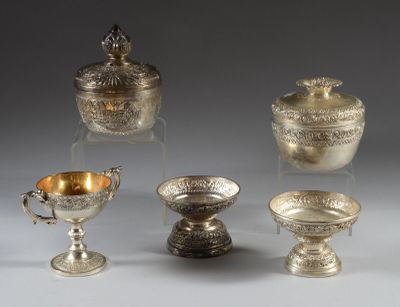 four silver dishes and a bowl on a stand on a gray surface
