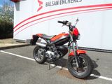 une moto rouge garée sur un parking à côté d'un camion blanc