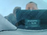 a reflection of a man in the rear view mirror of a car