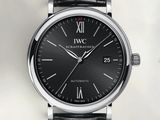 a close up of a black watch with roman numerals on the face