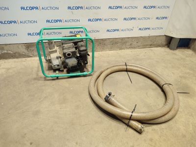 the hose is next to the water pump on the floor